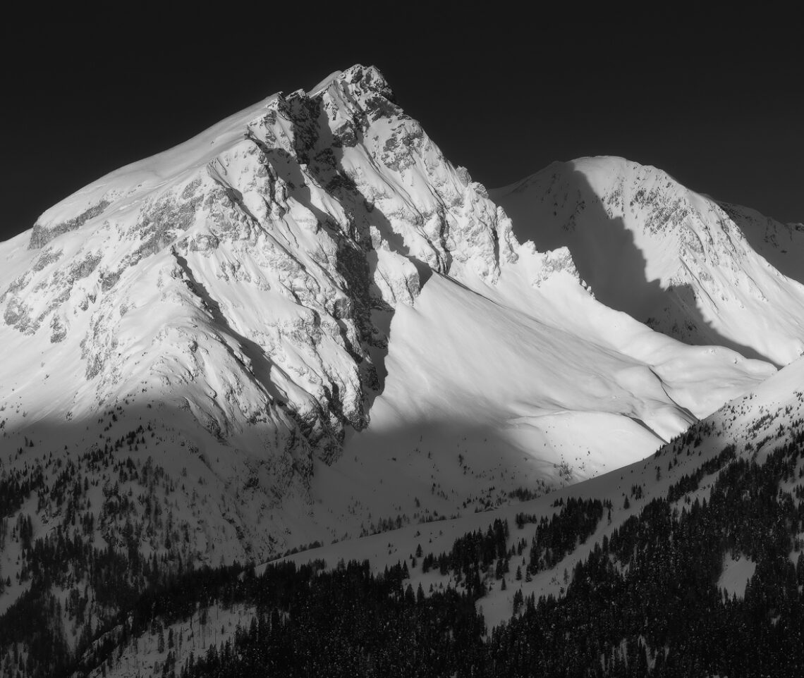 Un panorama immacolato viene risvegliato da un’alba lucente al termine di una notte gelida. Alpi Carniche, Italia.