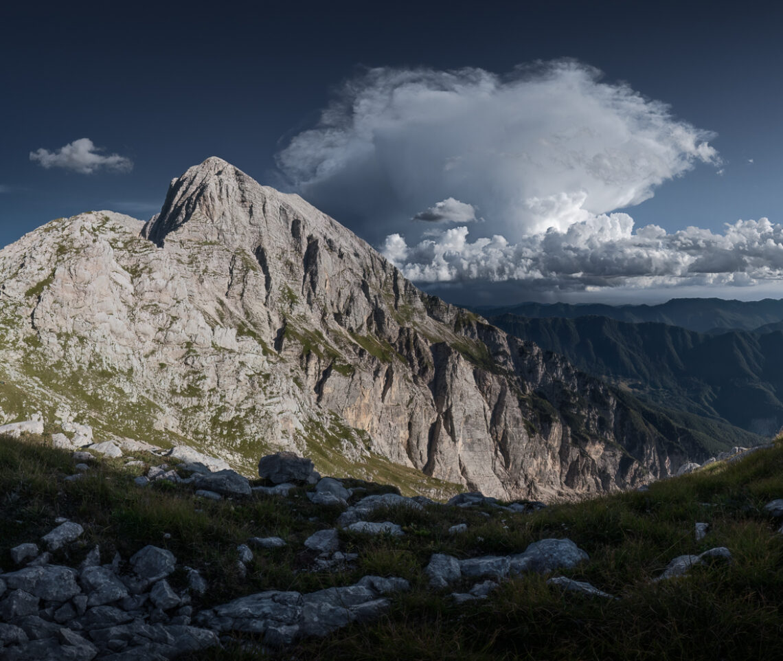 Il monte Canin, Alpi Giulie, si confronta con un isolato e impetuoso temporale di calore estivo che si abbatte al limite della pianura friulana. Parco Naturale Prealpi Giulie, Italia.