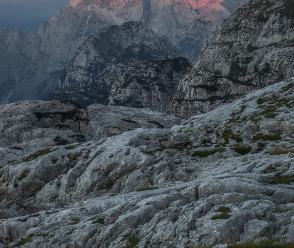 La luce del tramonto, come spesso accade, è la fiamma ardente che dà l’ultima espressione al giorno che sta per concludersi. Tutto è pronto per tramutarsi ancora una volta in un mondo pietrificato. Soprattuto qui, nel paesaggio carsico delle Alpi Giulie, Italia.