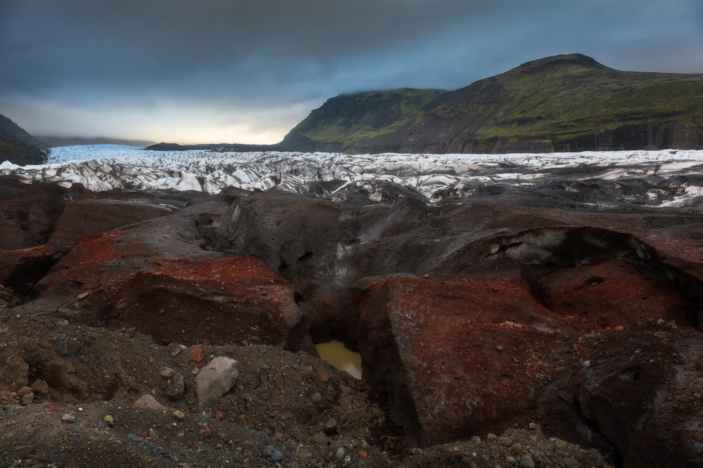 Sedimenti variopinti rivestono i blocchi di ghiaccio della fronte del ghiaccio Svínafellsjökull. In continuo, percettibile, movimento. Vatnajökull National Park, Islanda.