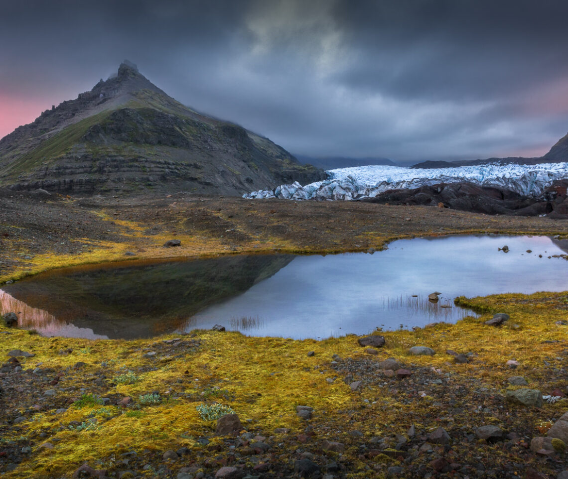 Dinanzi al ghiacciaio Svínafellsjökull, Il lungo tramonto estivo islandese regala colori inattesi dopo una giornata trascorsa sotto una costante pioggia battente. Vatnajökull National Park, Islanda.