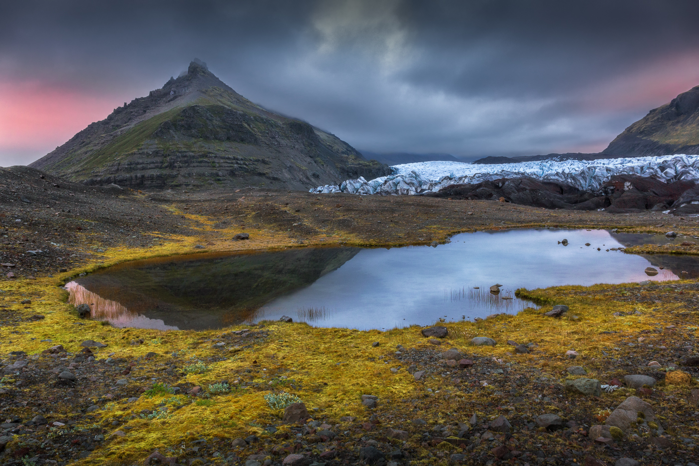 Dinanzi al ghiacciaio Svínafellsjökull, Il lungo tramonto estivo islandese regala colori inattesi dopo una giornata trascorsa sotto una costante pioggia battente. Vatnajökull National Park, Islanda.