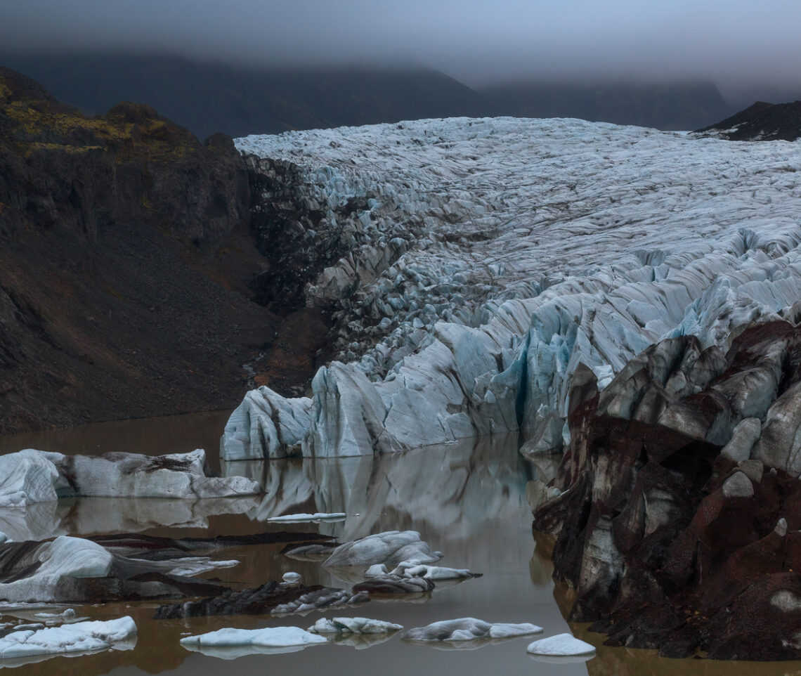 Lo scenario sembra silenzioso e immutabile, qui, dove il ghiacciaio Svínafellsjökull termina la sua discesa nel lago proglaciale da esso generato. Ma tutto, in realtà, è in costante trasformazione. Vatnajökull National Park, Islanda.