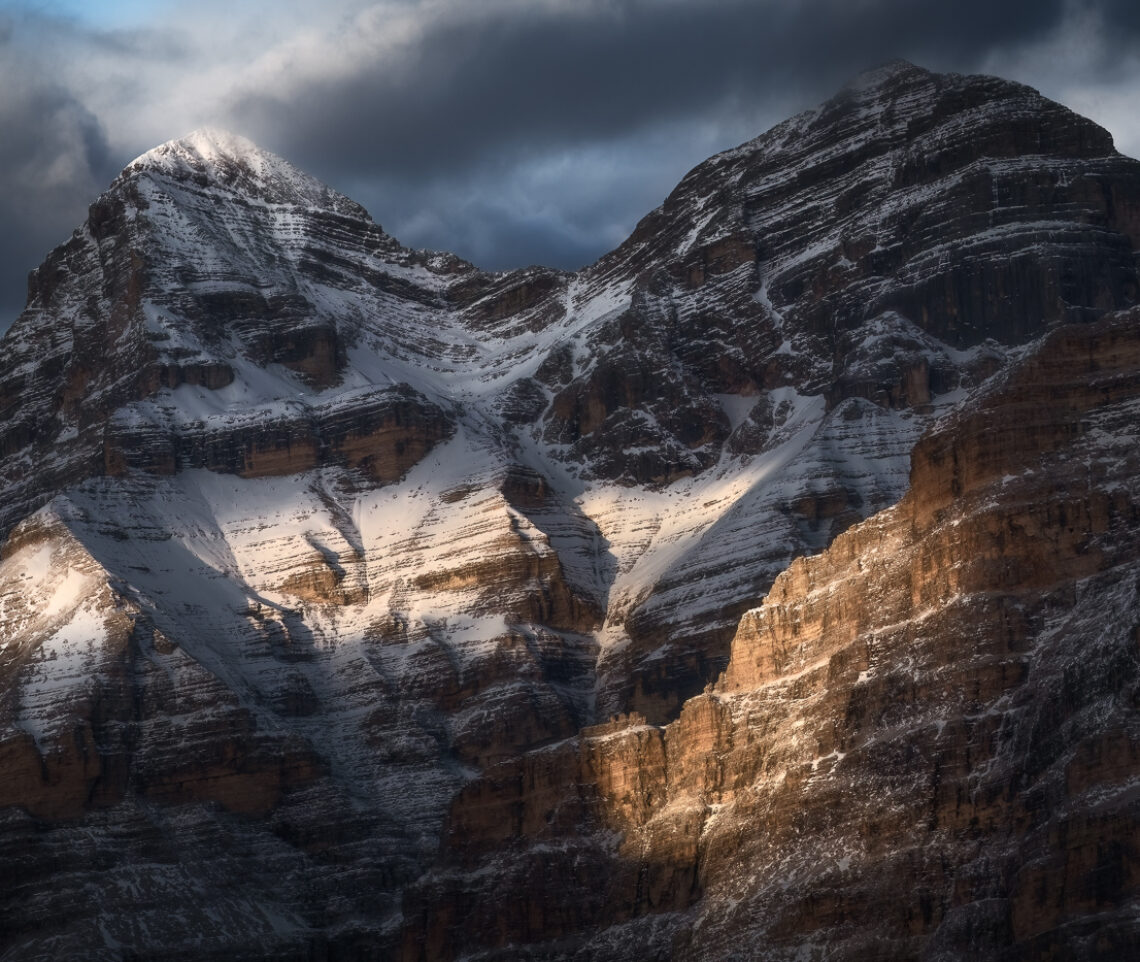 Uno squarcio di luce scalda le Tofane al tramonto. Dolomiti Ampezzane, Italia.