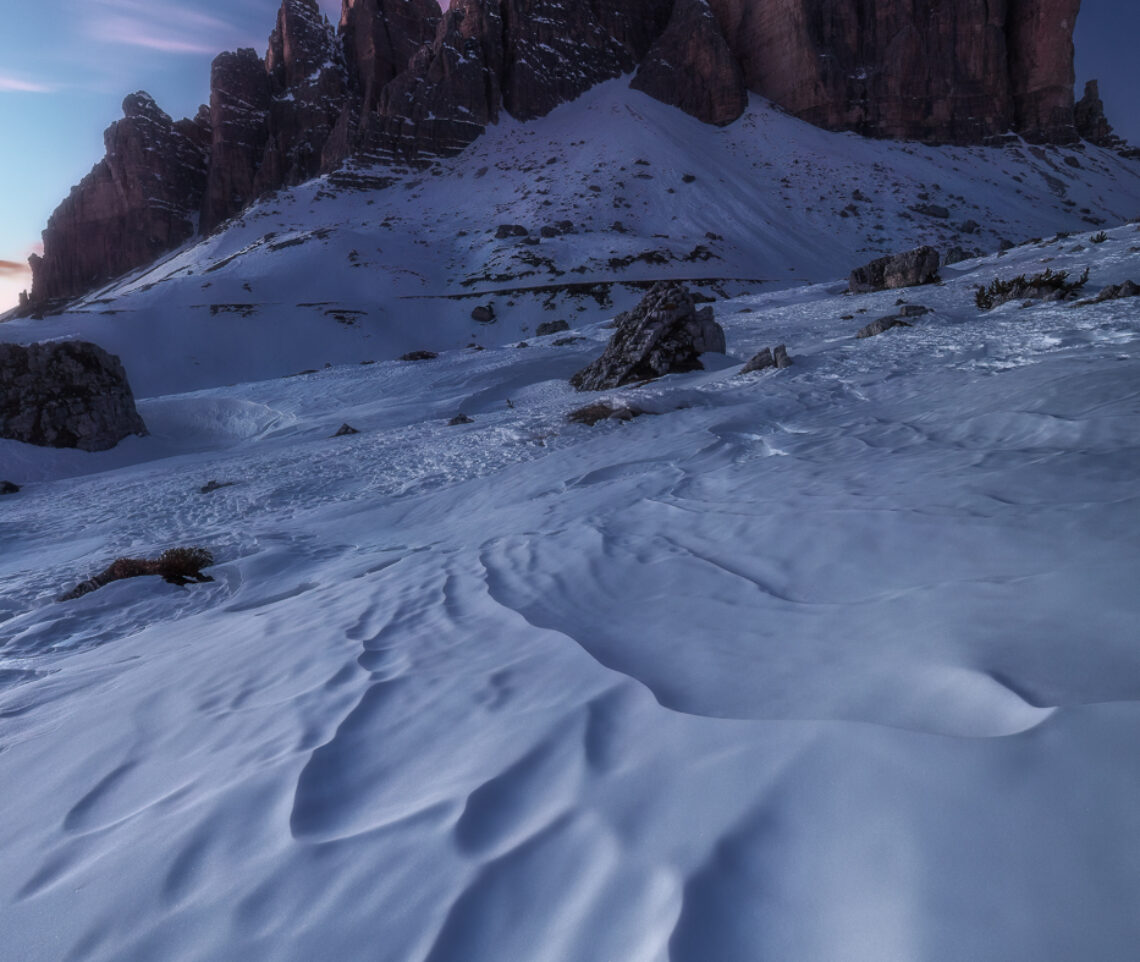 Una sublime ora blu invernale dove, tuttavia, rosa e rosso non vogliono proprio sfigurare. Parco Naturale Tre Cime, Dolomiti di Sesto, Italia.