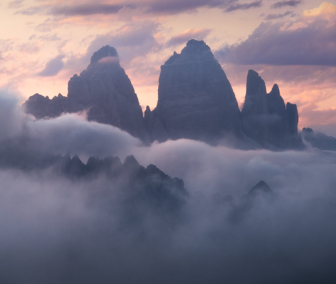 Miraggi celestiali al tramonto. Tre Cime di Lavaredo dal Gruppo delle Marmarole, Italia.