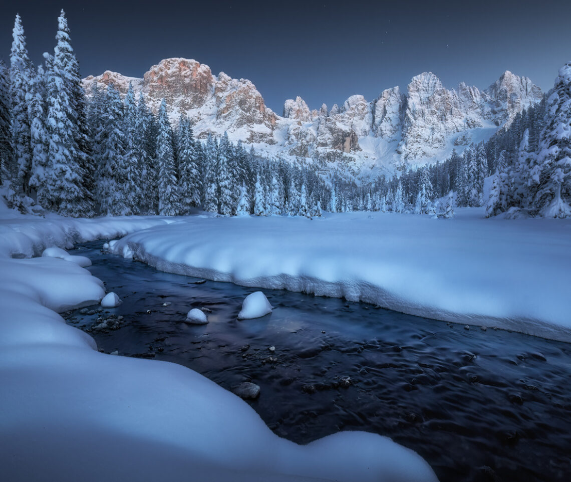 Le prime stelle fanno in cielo la loro comparsa, mentre la luce blu del crepuscolo, qui sulla Terra, scolpisce le ultime visioni di bellezza del giorno. Parco Naturale Paneveggio Pale di San Martino, Italia.